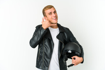 Young caucasian man holding a motorbike helmet isolated on white background