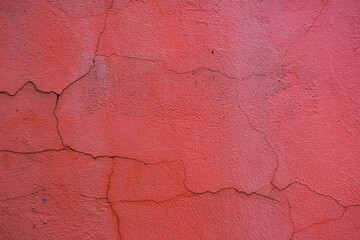 Rough textured red wall with stains, selective focus