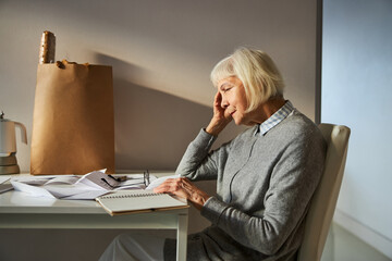 Tired senior lady having a temporal headache