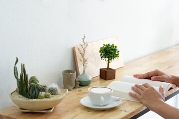 Mockup image of a woman reading a book on table with blank pages of book