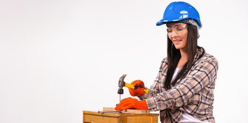 Banner. A woman builder in a helmet, gloves and glasses with a hammer on a white background.