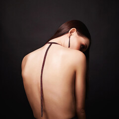 beautiful woman with necklace on her naked back