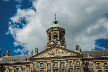 Fototapeta na wymiar Close-up of facade with sculptures and dome with golden clock in the Royal Palace of Amsterdam. The capital of Netherlands.