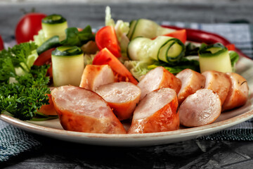 Fried homemade sausage with fresh vegetables on a platter