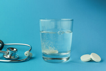 effervescent vitamin C tablet dissolves in water. a glass of water and an effervescent paracetamol tablet. the medicine tablet dissolves in a glass of water