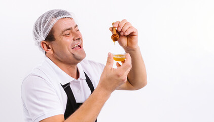 Cheerful chef with a bowl of fragrant honey on a white plate with side blank space.