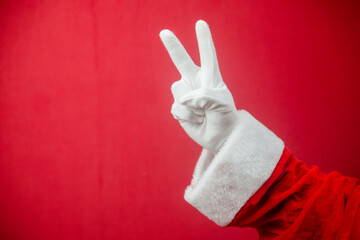 Santa Claus showing V victory sign. Closeup photo of gloved hand. Merry Xmas and Happy New Year...