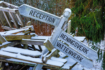 Solbacka, Sweden Old direction signs in Swedish and outdoor tables piled high at the abandoned Solbacka boarding school. Made famous by Jan Guillou's novel Ondskan, it is now in ruin.
