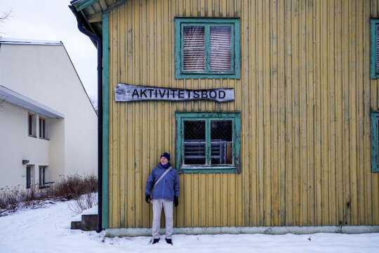 Solbacka, Sweden  A person standing at an abandoned house, and a sign in Swedish for the activity house.