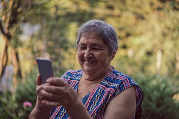Very old happy woman using smartphone outdoors. Old generations using new technologies mobile phone