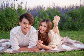 Young couple lying on a blanket on the lens