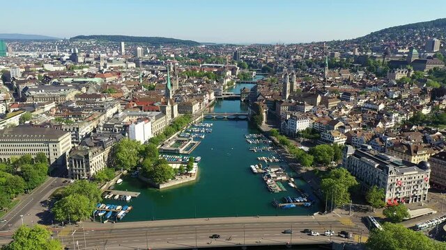 Aerial drone footage of the famous Zurich old town along the Limmat river and lake Zurich on a sunny summer day in Switzerland largest city. 