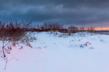 Snow-covered dunes at sunset, winter landscape in Jastarnia on the coast of the Hel Peninsula. Poland