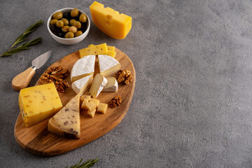 Assorted cheeses with nuts, olives and rosemary.