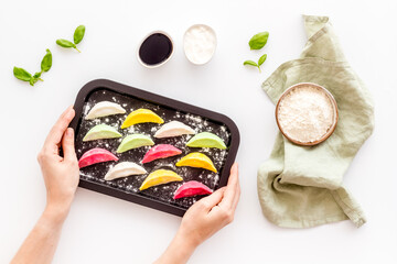Colorful dumplings tortellini on baking sheet, top view