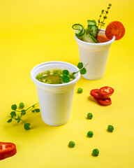 Take-out soup, vegetable soup in a glass, tomato and pea soup. Soup to go