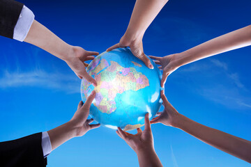 The team holding a globe together