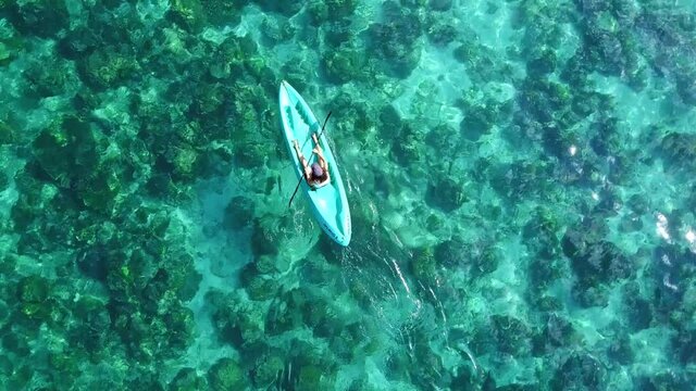 Woman On A Kayak Paddling On Turquoise Paradise Beach At El Nido, Palawan Island, Philippines. - Aerial Ascending Shot