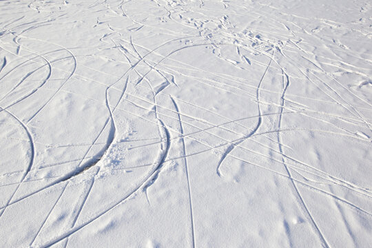 Skate tracks on ice with snowy snow. Winter background.