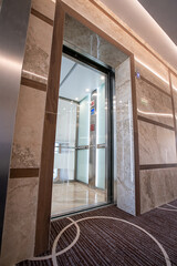 Lift with transparent glass doors in modern building