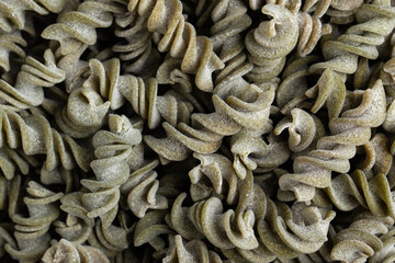 Spinach Fusilli dry background. Gluten free pasta. 