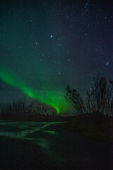Fototapeta premium Strip of a northern light with clouds on the sky