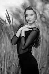 Beautiful sexy blonde girl in black blouse posing in reeds