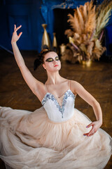 Fototapeta premium Ballerina sitting on the floor and dancing in a luxurious interior