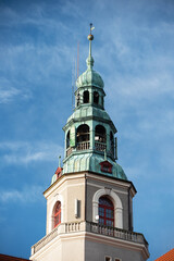 Fototapeta na wymiar A beautiful building of the town hall with a magnificent tower in the city center of Olsztyn in Warmia, Poland against the background of a blue sky during the day