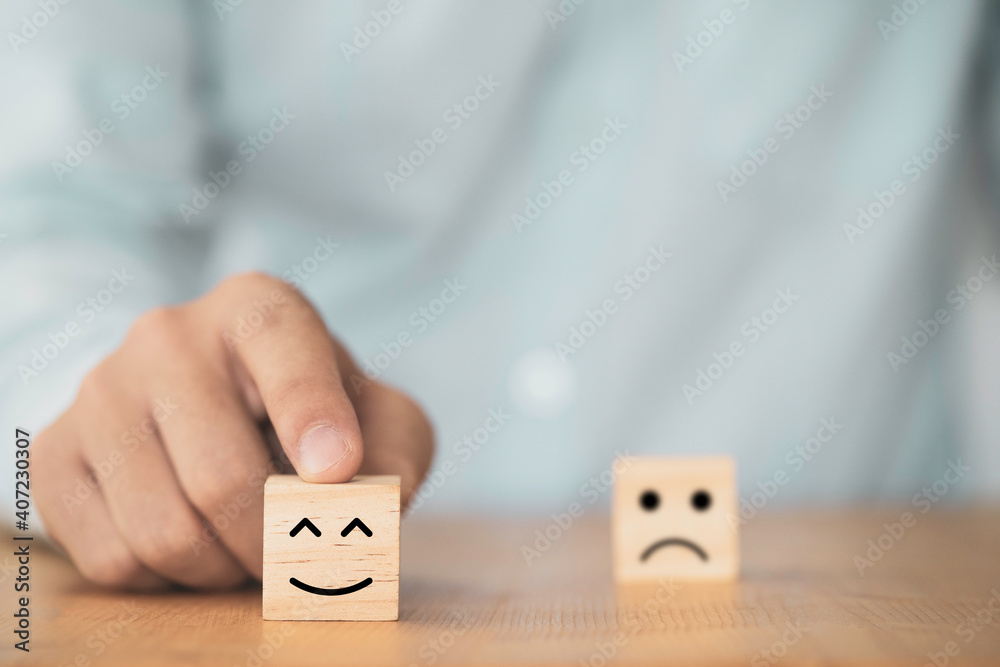 Poster businessman use finger to pointing smile face which print screen on wooden cube block , emotion and 