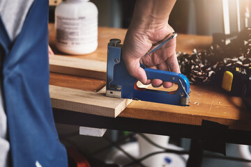 Entrepreneur  Woodwork holding a Tacker to assemble the wood pieces as the customer ordered