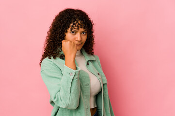 Young african american afro woman isolated showing fist to camera, aggressive facial expression.