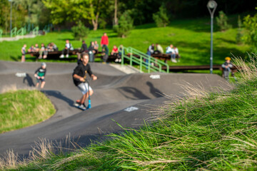 Pomptrack for cyclists, inline skaters, nestled in the grass outside by day