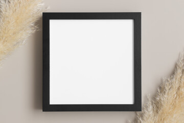 Top view of a black square frame mockup with pampas decoration.