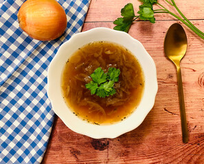 Clear, vegetarian onion soup with parsley.