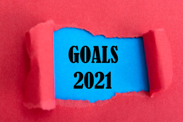 GOALS 2021. text on torn paper. on a blue background.