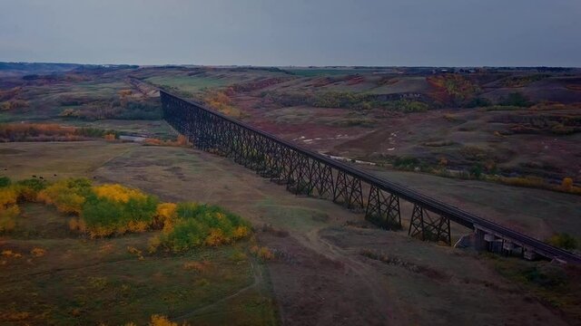 Flying over a historic train trestle crossing an expansive Battle River Valley.