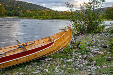 Obraz premium Wooden boats on stones on ariver in Norway