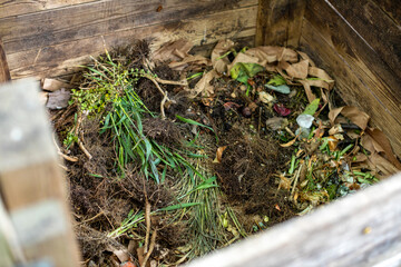 Garden compost bin full of organic waste
