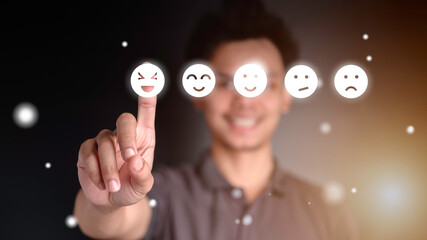 Businessman pressing feeling icon on face from a virtual screen. Ideas about satisfaction and...