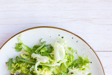 White ceramic plate with fresh salad on wooden background