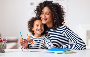 Excited ethnic mother and son doing homework