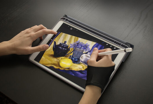 A girl in a special glove draws a still life picture with a pencil on an electronic tablet. The concept of inspiration, creativity, self-development, hobby, art
