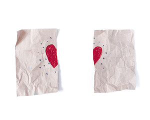The drawing of the heart are on rough crumpled paper. The sheet is torn in half. The symbol of a break in relations, divorce.