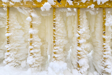 Metal fence covered with snow and ice