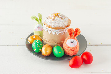 Arrangement decoration Happy Easter holiday background concept. Easter cakeon a plate with handmade knitted eggs. Pastel colors.