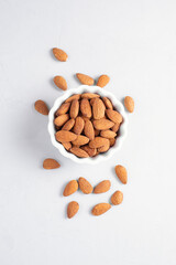 Natural organic roasted unpeeled almond on a light background top view. The basis of norm fats and...