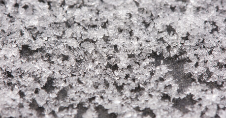 Grains of snow on a gray background. Natural background of snow and frost. Shallow depth of field