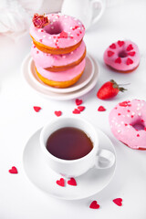 Cup of coffee and pink doughnuts on the white background. Valentine's Day concept.