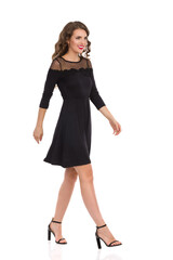 Smiling Woman Is Walking In Elegant Black Dress And High Heels.